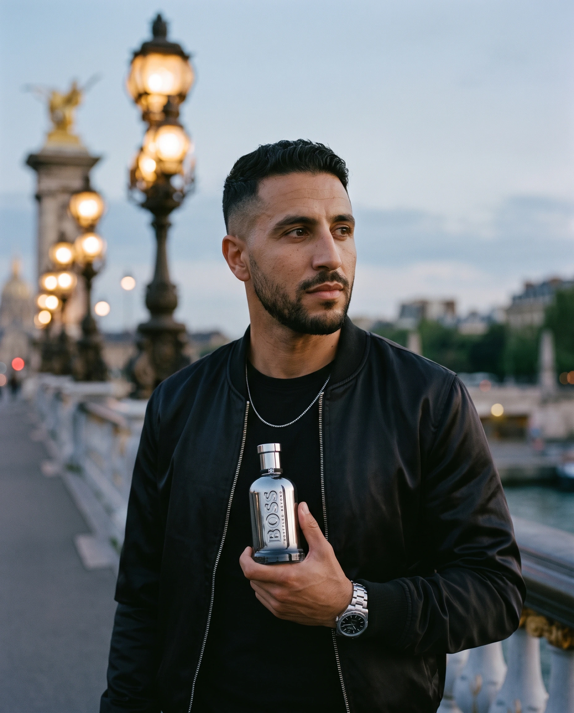 Homme tenant le flacon Hugo Boss Bottled Beyond Intense sur le pont Alexandre III à Paris